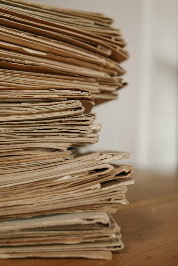 Close-up of vintage paper stacks on a wooden table, evoking a classic office setting.